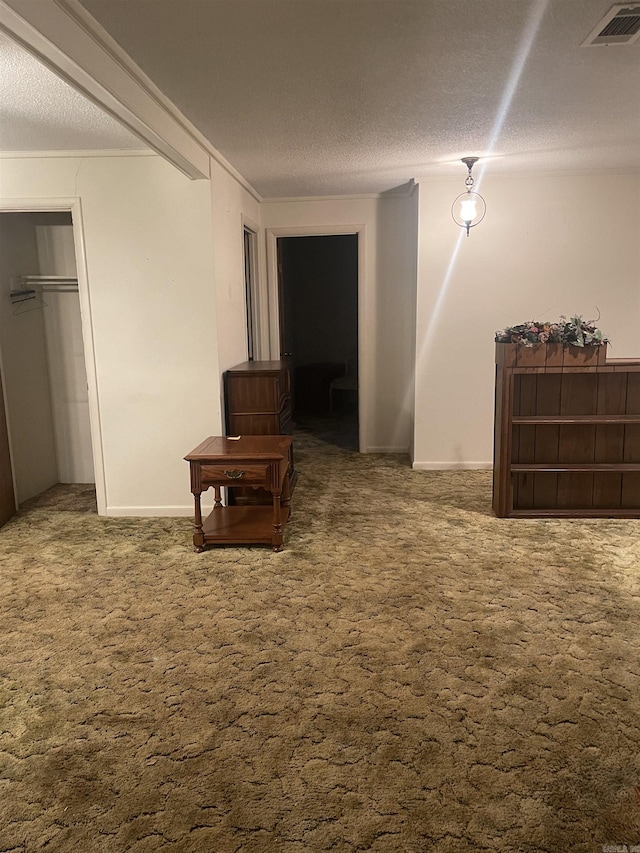 corridor featuring baseboards, carpet flooring, a textured ceiling, and visible vents