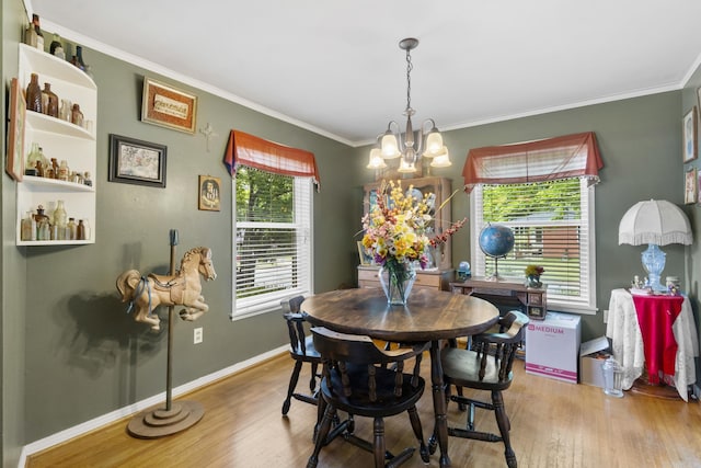 dining room with crown molding, baseboards, a chandelier, and wood finished floors