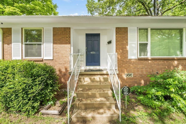 entrance to property featuring brick siding
