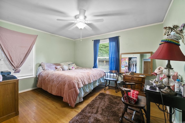 bedroom featuring crown molding, baseboards, and wood finished floors