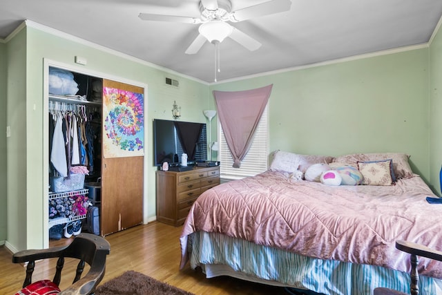 bedroom with visible vents, ornamental molding, and wood finished floors