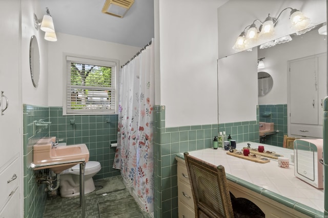 bathroom with toilet, tile patterned floors, a wainscoted wall, tile walls, and visible vents