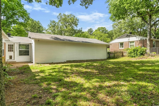 back of property with fence and a yard