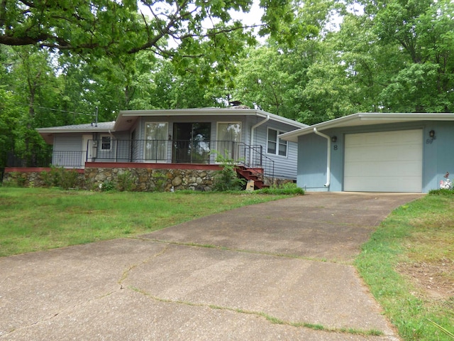 ranch-style home with a garage, driveway, a front yard, and covered porch