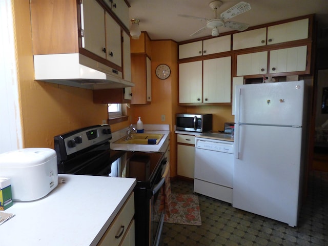 kitchen featuring a ceiling fan, appliances with stainless steel finishes, a sink, dark floors, and under cabinet range hood