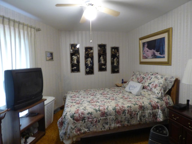 bedroom featuring ceiling fan, multiple windows, and wood finished floors