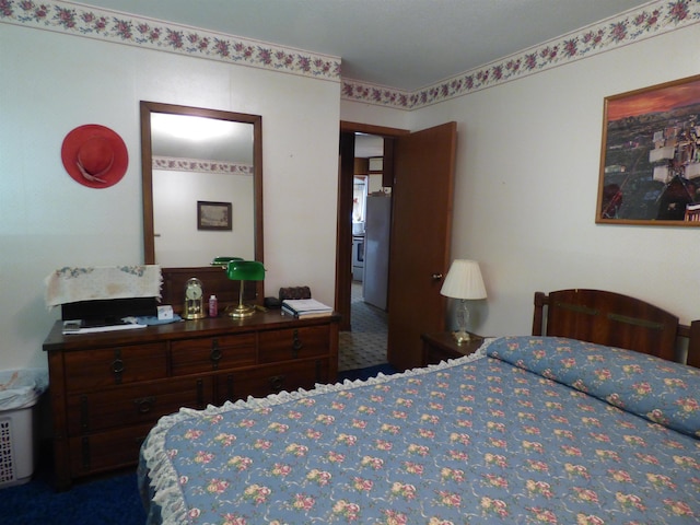bedroom featuring carpet floors and freestanding refrigerator