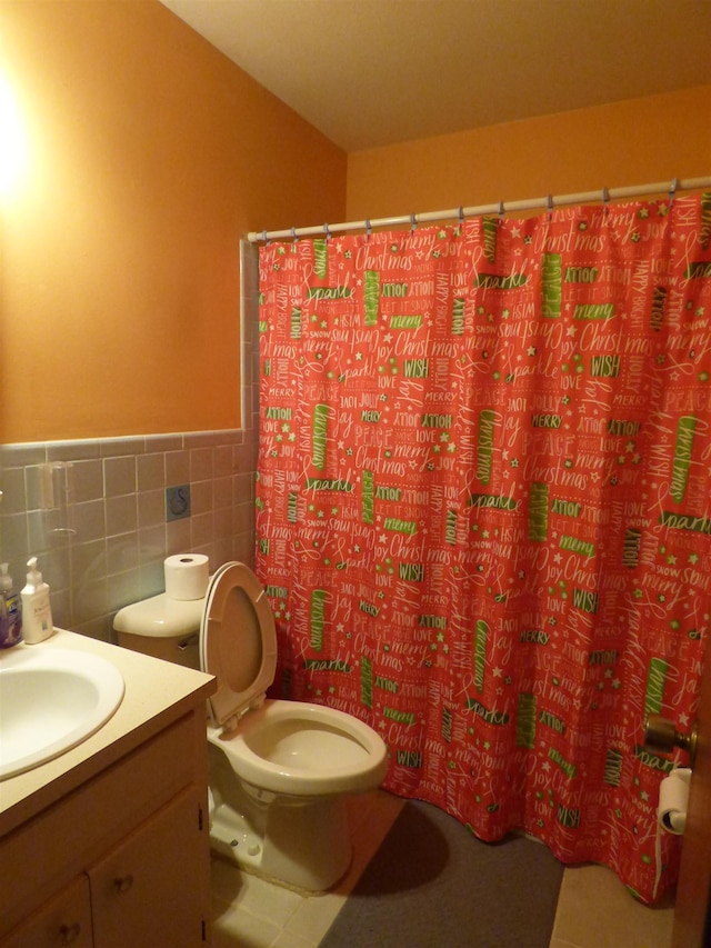 bathroom with vanity, toilet, a wainscoted wall, tile walls, and a shower with curtain