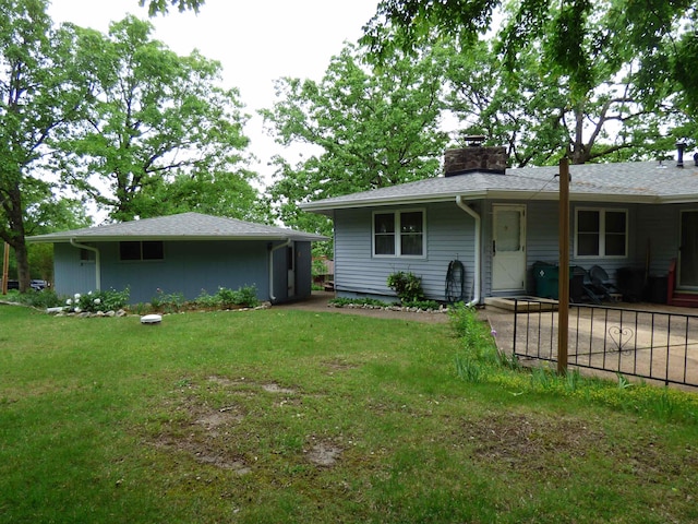 rear view of property with a lawn and a chimney