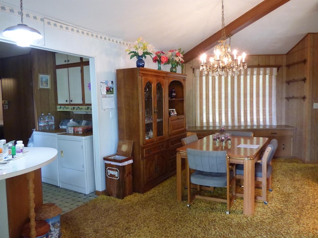 dining room featuring wooden walls, a notable chandelier, washer and dryer, and vaulted ceiling