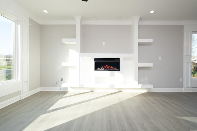 2919 Martel Ave, Little Rock, AR 72206 - unfurnished living room featuring baseboards, ornamental molding, wood finished floors, and a warm lit fireplace
