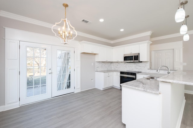 2919 Martel Ave, Little Rock, AR 72206 - kitchen with ornamental molding, a peninsula, stainless steel microwave, a sink, and range with electric cooktop