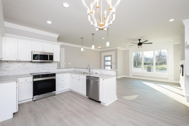 2919 Martel Ave, Little Rock, AR 72206 - kitchen featuring stainless steel appliances, light wood-type flooring, ornamental molding, and a peninsula