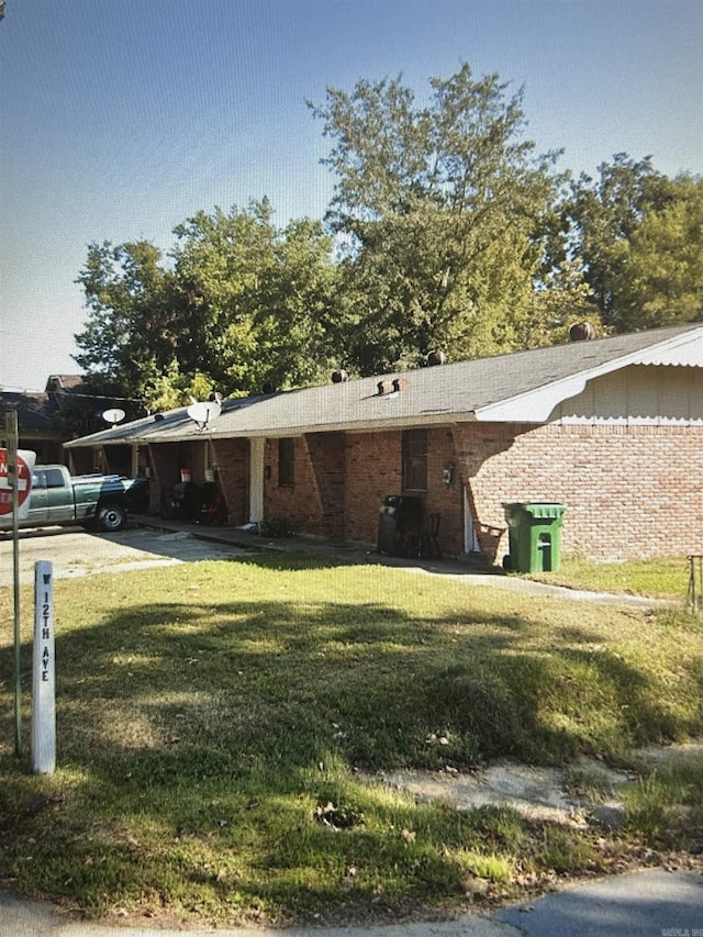 view of front of house with brick siding and a front yard