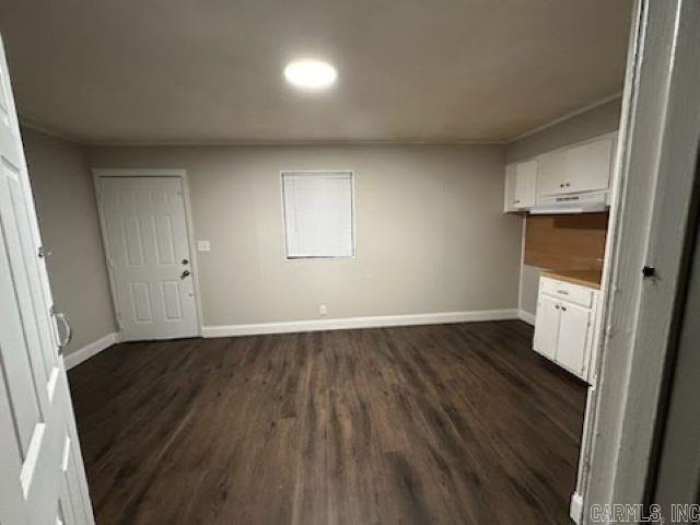 interior space with baseboards and dark wood-style flooring