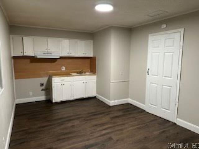 clothes washing area featuring baseboards, ornamental molding, dark wood-style flooring, and a sink