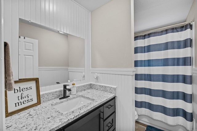 full bath with vanity, wainscoting, and curtained shower