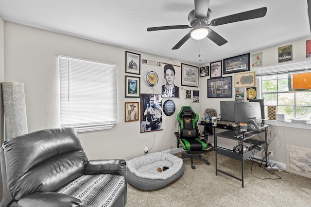 carpeted office featuring baseboards and a ceiling fan