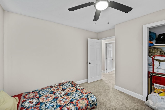 bedroom featuring light colored carpet, a ceiling fan, and baseboards