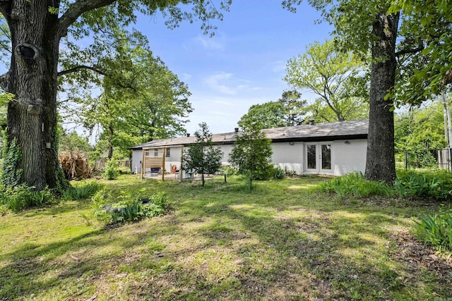 view of yard with french doors and fence