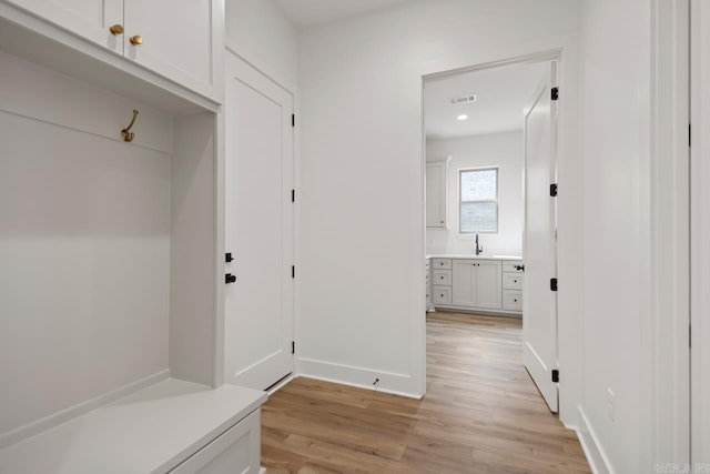 mudroom with a sink, light wood finished floors, recessed lighting, baseboards, and visible vents