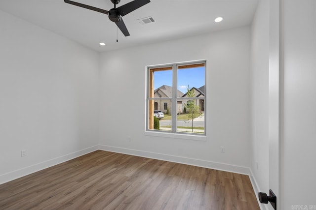unfurnished room with visible vents, a ceiling fan, baseboards, and wood finished floors