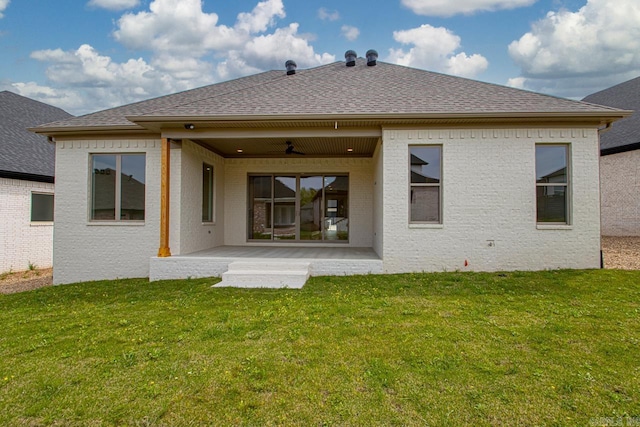 back of property featuring roof with shingles, brick siding, a ceiling fan, a patio, and a yard