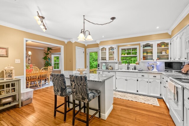 3 E Lake Dr, North Little Rock, AR 72116 - kitchen with a kitchen island, white electric stove, crown molding, a breakfast bar, and white cabinetry