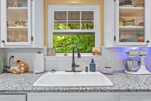 3 E Lake Dr, North Little Rock, AR 72116 - interior space featuring backsplash, a sink, light stone counters, glass insert cabinets, and white cabinetry