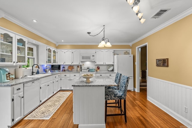 kitchen featuring crown molding, a sink, white appliances, white cabinetry, and visible vents