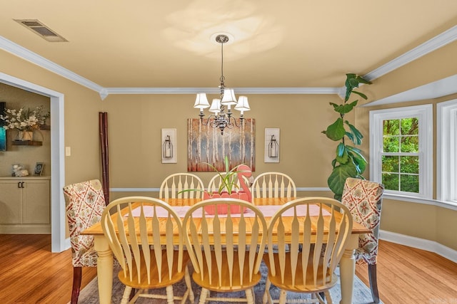 3 E Lake Dr, North Little Rock, AR 72116 - dining area with visible vents, baseboards, light wood finished floors, an inviting chandelier, and ornamental molding