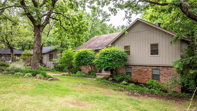 exterior space featuring a yard and brick siding