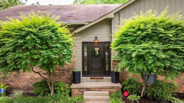 entrance to property featuring brick siding and board and batten siding