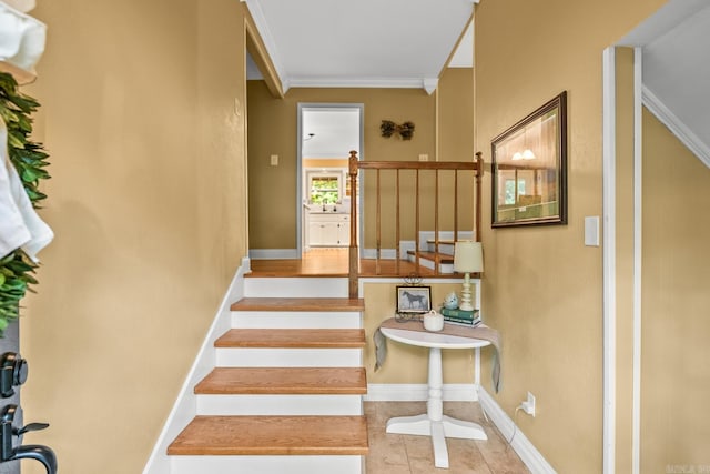 staircase featuring baseboards, ornamental molding, and tile patterned flooring