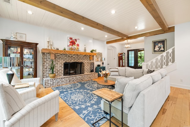 living room with arched walkways, light wood finished floors, recessed lighting, and beam ceiling