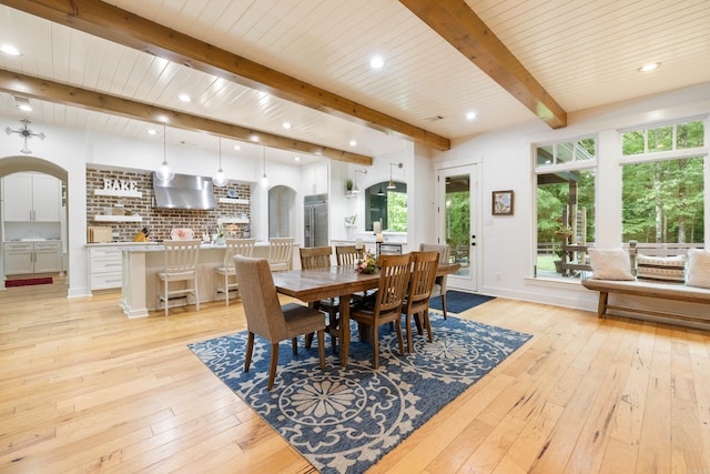 dining area with recessed lighting, arched walkways, beamed ceiling, and light wood finished floors