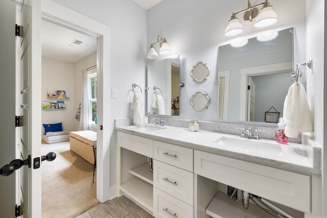 ensuite bathroom featuring double vanity, visible vents, a sink, and ensuite bathroom