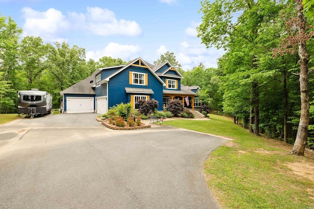 view of front facade featuring covered porch, an attached garage, a front lawn, and aphalt driveway