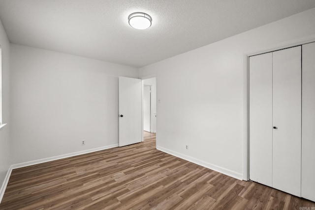 22 Colony Rd, Little Rock, AR 72227 - unfurnished bedroom featuring a textured ceiling, baseboards, a closet, and wood finished floors