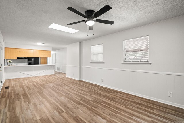 22 Colony Rd, Little Rock, AR 72227 - unfurnished living room featuring baseboards, a ceiling fan, a textured ceiling, and wood finished floors