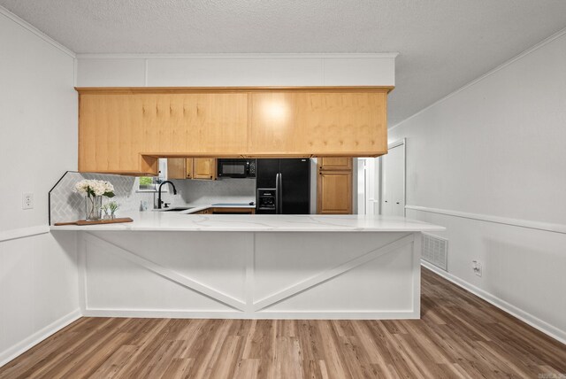 22 Colony Rd, Little Rock, AR 72227 - kitchen featuring wood finished floors, a sink, light countertops, black appliances, and a peninsula
