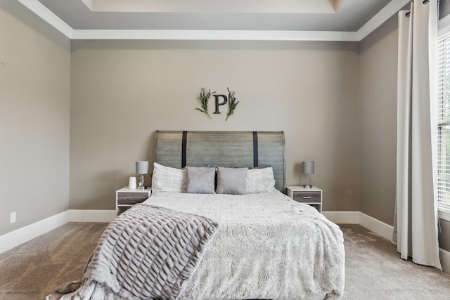 bedroom with carpet floors, baseboards, and a tray ceiling