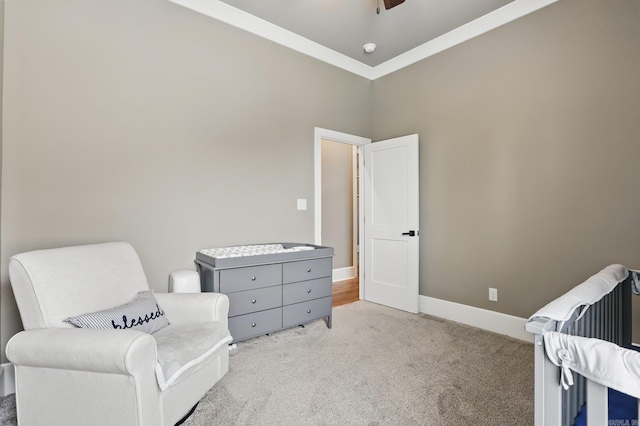 sitting room featuring baseboards, a ceiling fan, and light colored carpet