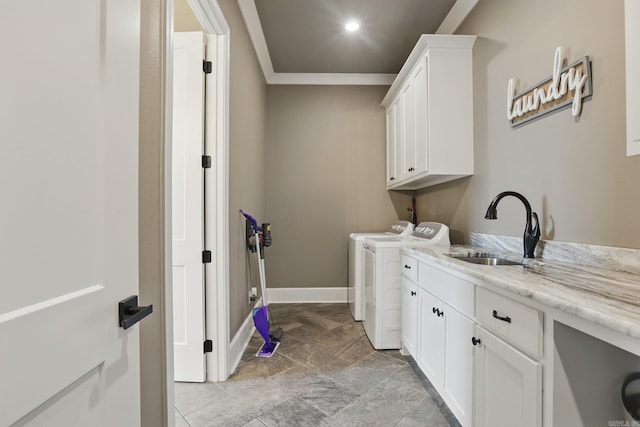 laundry room with cabinet space, crown molding, a sink, baseboards, and washer and clothes dryer