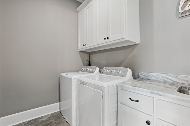 laundry room featuring baseboards, washing machine and dryer, and cabinet space