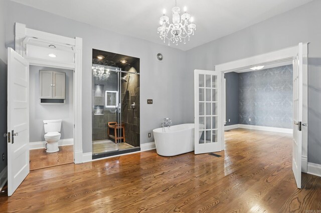 spare room with french doors, baseboards, wood finished floors, and a chandelier