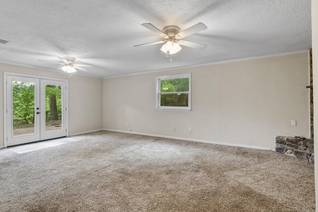 carpeted spare room with a ceiling fan, a textured ceiling, ornamental molding, and french doors