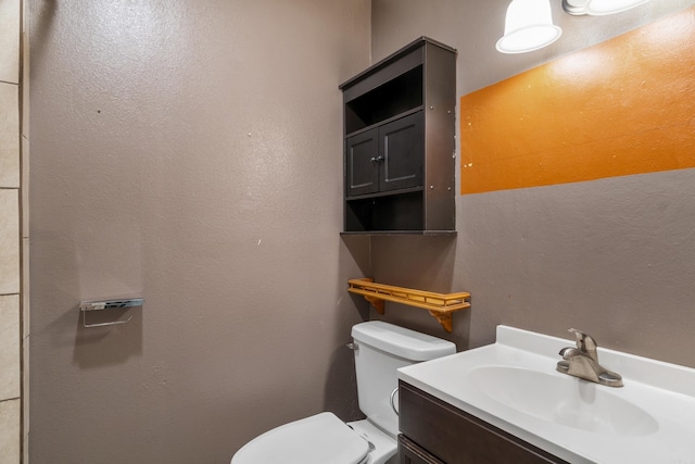 half bathroom featuring vanity and toilet