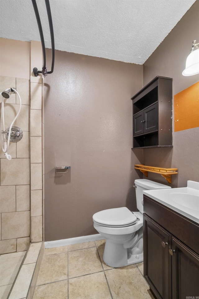 full bathroom with vanity, a textured ceiling, a tile shower, and toilet
