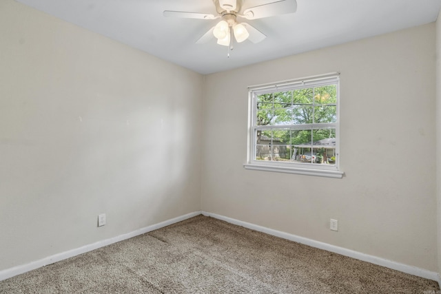 carpeted empty room with baseboards and a ceiling fan